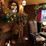 The Drinks Room fireplace with a nice chair, decorated for the holiday season.